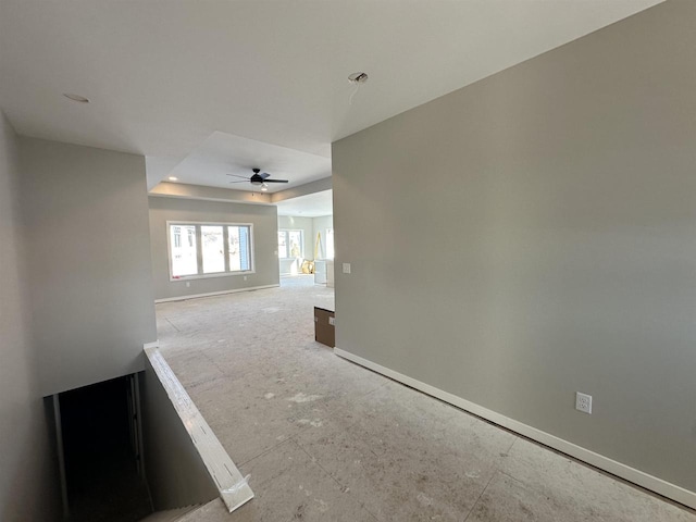 unfurnished room with ceiling fan and baseboards