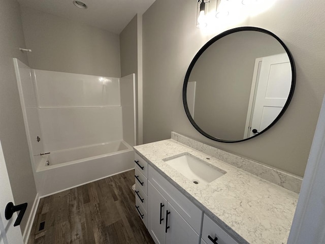 bathroom with shower / bathing tub combination, wood finished floors, and vanity