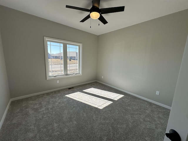 spare room featuring carpet floors, a ceiling fan, visible vents, and baseboards