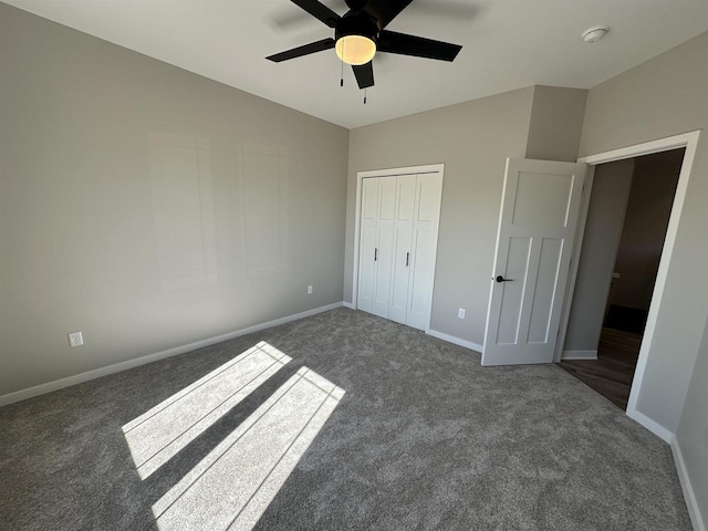 unfurnished bedroom with lofted ceiling, carpet floors, a ceiling fan, baseboards, and a closet