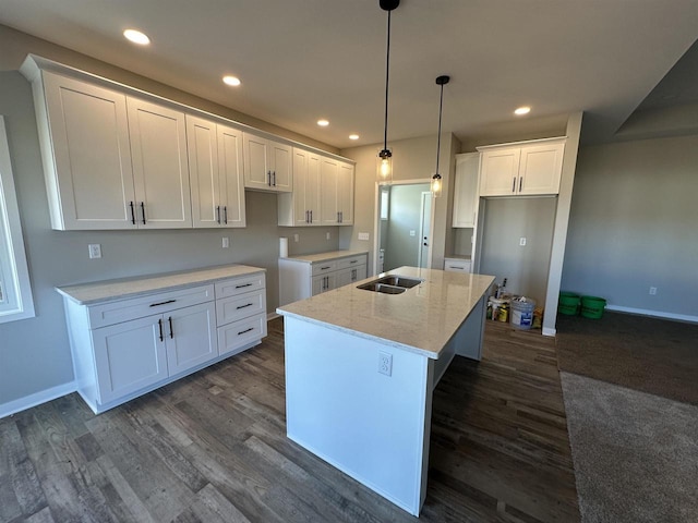 kitchen with recessed lighting, white cabinets, a kitchen island with sink, and dark wood finished floors