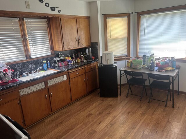 kitchen with sink, light hardwood / wood-style flooring, and backsplash