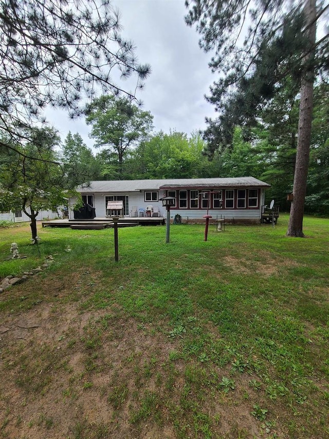 view of front of home featuring a wooden deck and a front yard