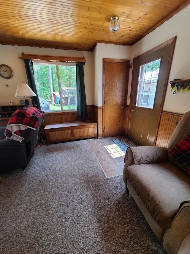 living room featuring wooden ceiling and carpet