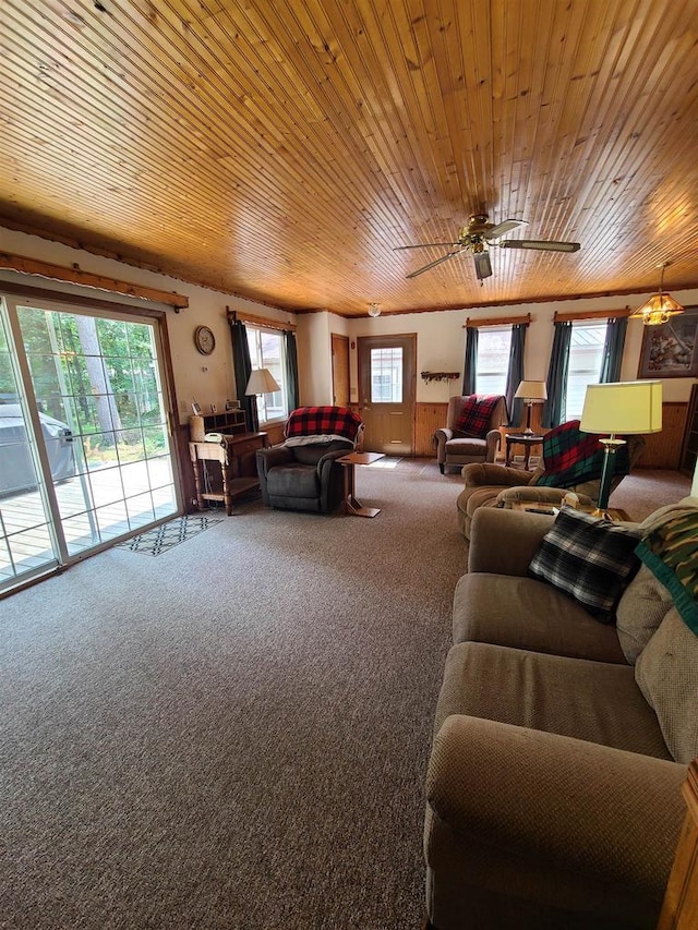 living room with ceiling fan, carpet flooring, and wooden ceiling