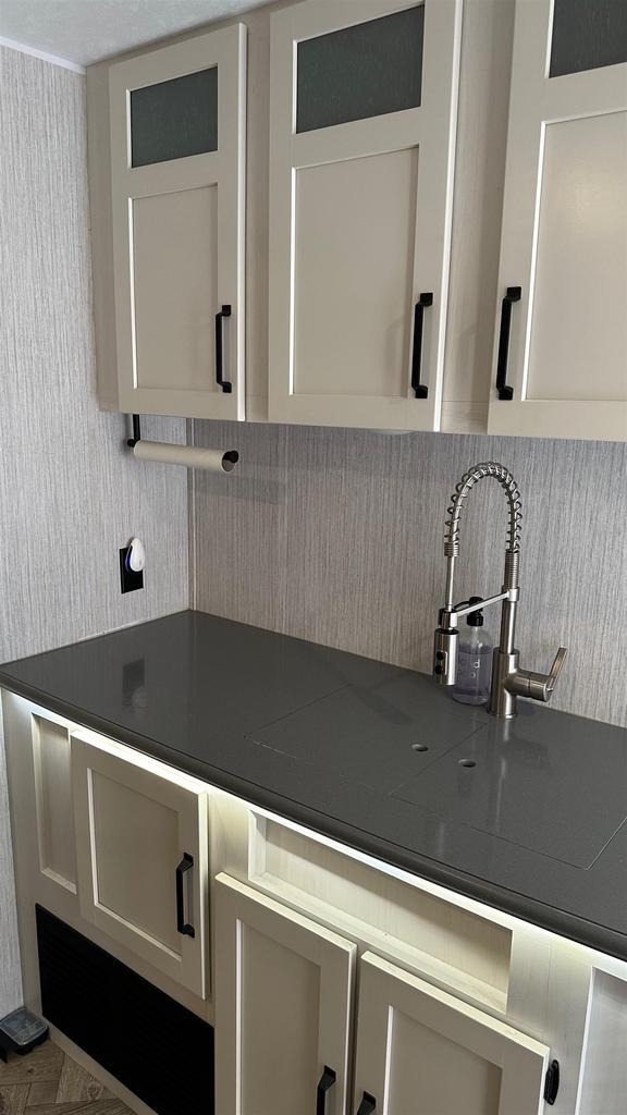 kitchen featuring white cabinets and parquet flooring