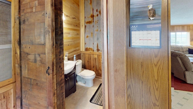 20649 Julia Rd, Clifton, WI 54618 - bathroom featuring vanity, toilet, and wood walls