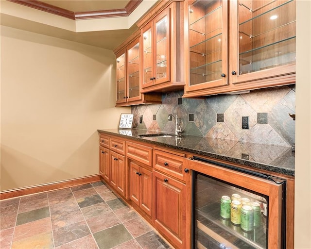 kitchen featuring tasteful backsplash, sink, dark tile patterned flooring, wine cooler, and ornamental molding