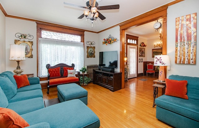 living room with wood-type flooring, ceiling fan, and crown molding