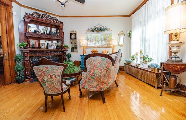 sitting room with crown molding, a fireplace, and hardwood / wood-style flooring