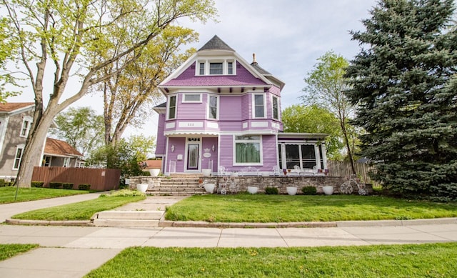 victorian house featuring a front lawn