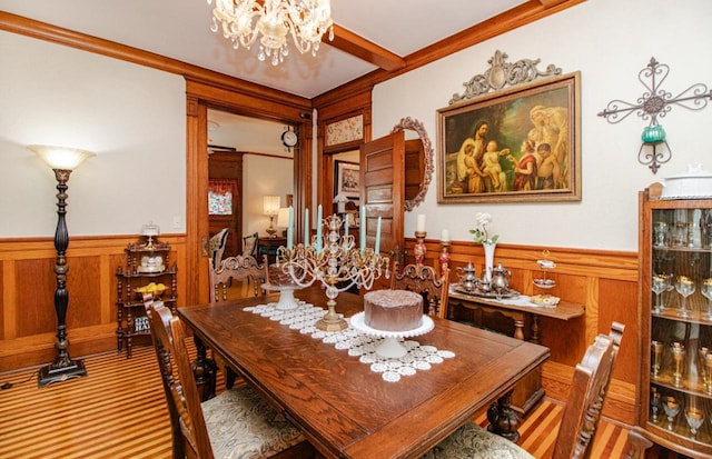 dining space with beam ceiling, a notable chandelier, crown molding, and carpet