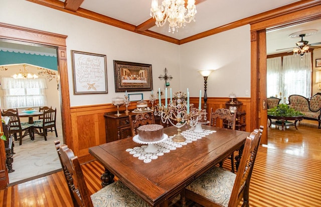 dining room with crown molding, plenty of natural light, hardwood / wood-style floors, and ceiling fan with notable chandelier