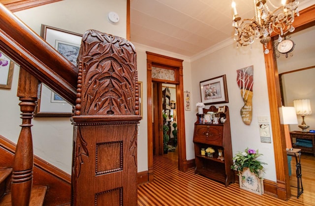 hall with ornamental molding and a notable chandelier