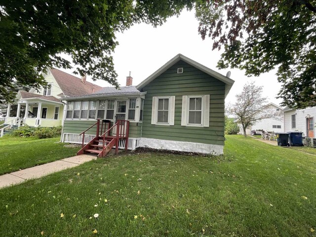 bungalow-style home with a front lawn