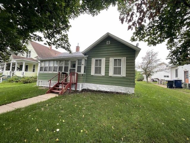 bungalow with a front yard and a sunroom