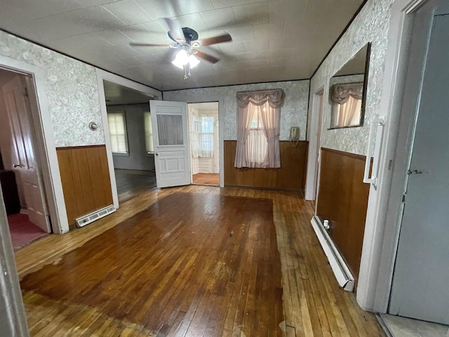 interior space featuring hardwood / wood-style flooring, plenty of natural light, and a baseboard heating unit