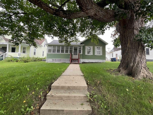 view of front of house with a sunroom and a front lawn