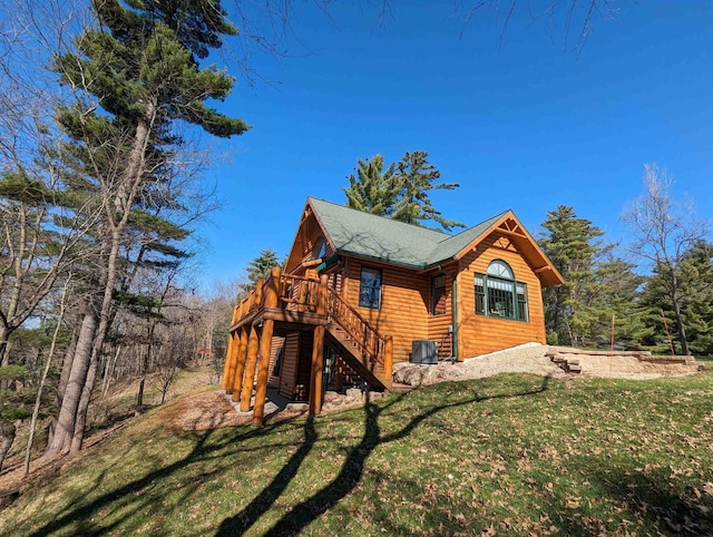 view of home's exterior with a wooden deck and a lawn