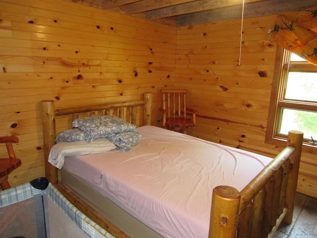 bedroom with wood walls and beam ceiling