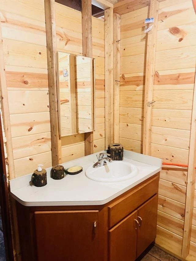 bathroom with vanity and wood walls