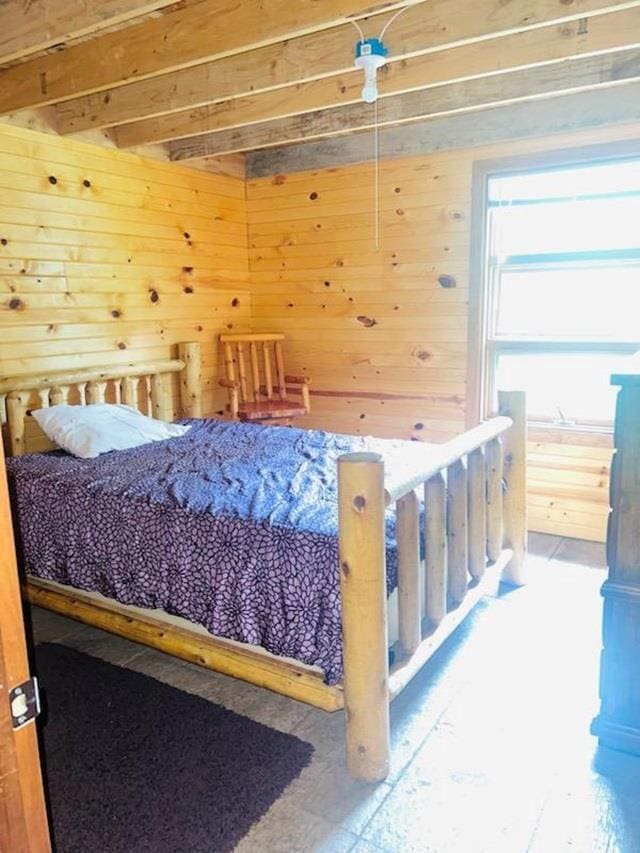 bedroom featuring wooden walls