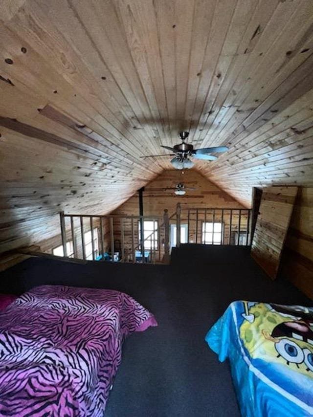 bedroom featuring wooden ceiling, lofted ceiling, wood walls, and ceiling fan