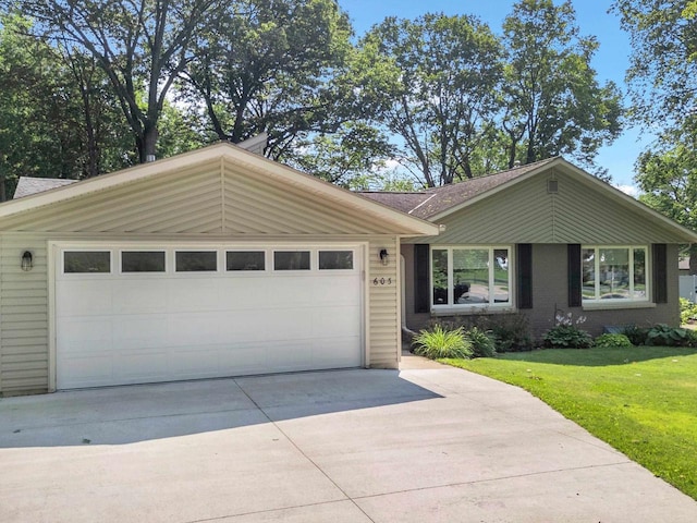 single story home with a garage and a front lawn