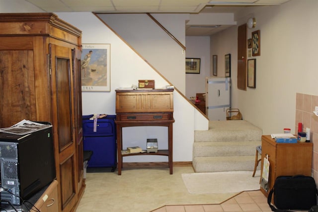 interior space with light tile patterned floors and a paneled ceiling