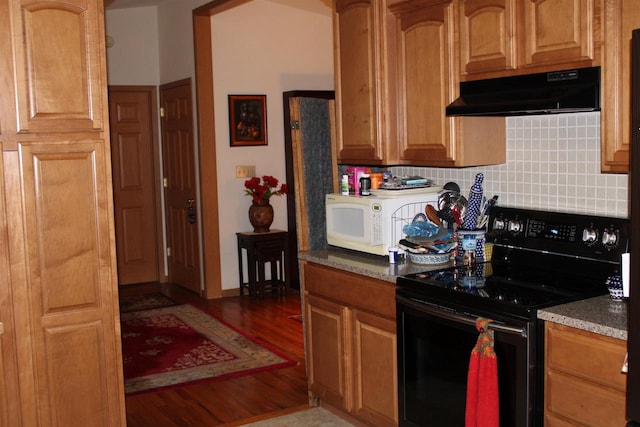 kitchen featuring dark stone countertops, black electric range, dark hardwood / wood-style flooring, and tasteful backsplash