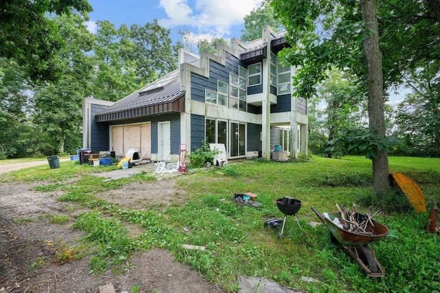 rear view of property featuring a balcony and a lawn