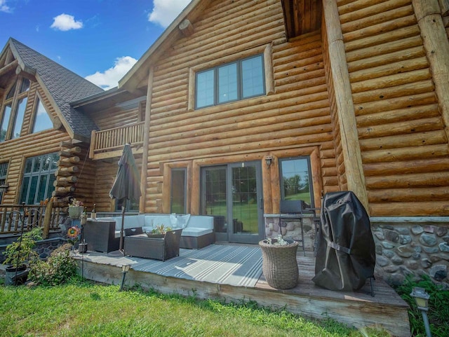 rear view of house with a wooden deck and outdoor lounge area