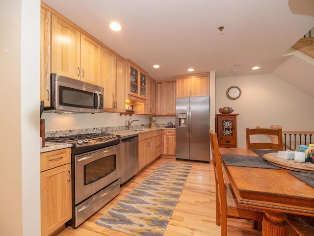 kitchen with sink, light hardwood / wood-style flooring, stainless steel appliances, light stone counters, and light brown cabinetry