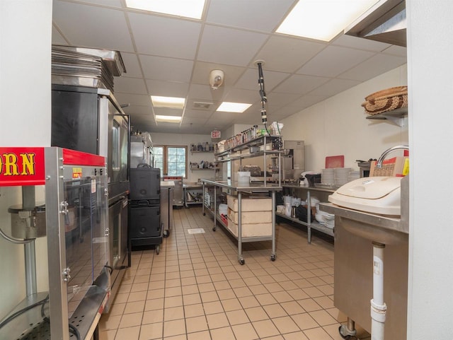 kitchen featuring a paneled ceiling and light tile patterned floors