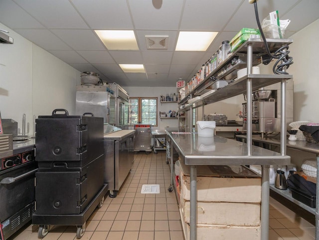 kitchen featuring light tile patterned floors and a drop ceiling