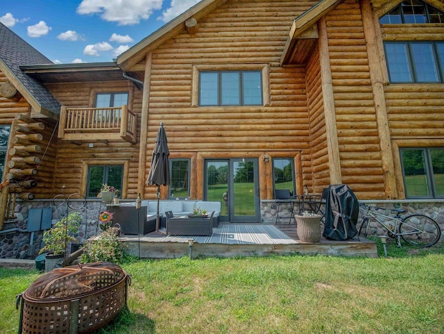 rear view of house featuring a wooden deck, a yard, and an outdoor living space with a fire pit