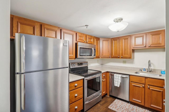 kitchen featuring sink, dark hardwood / wood-style flooring, stainless steel appliances, and light stone countertops