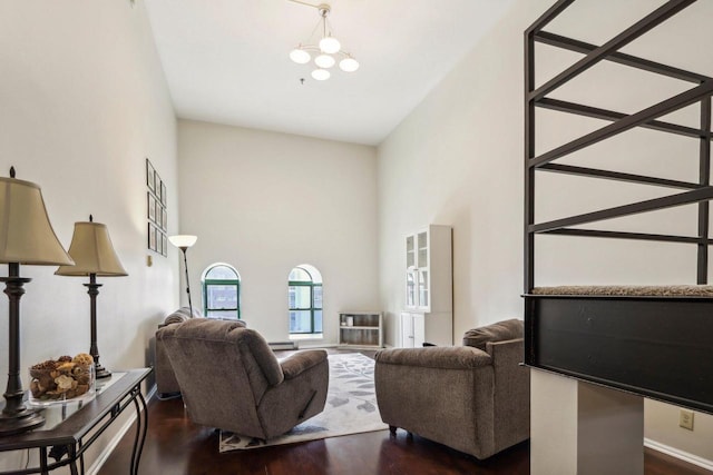 living room with a chandelier, dark hardwood / wood-style floors, and a high ceiling