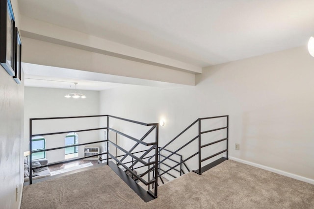 stairs with a notable chandelier and carpet floors