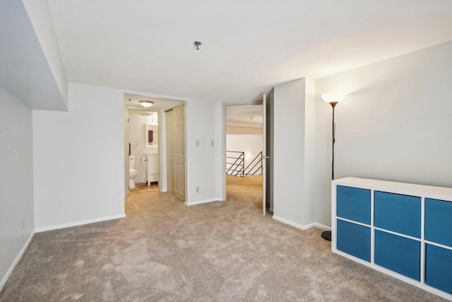 unfurnished bedroom with connected bathroom and light colored carpet