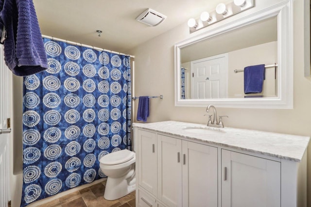 bathroom featuring vanity, toilet, and tile patterned flooring