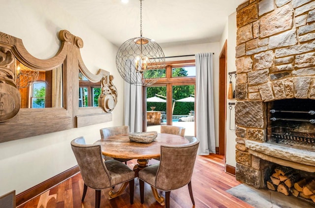 dining area with a healthy amount of sunlight, wood-type flooring, and a fireplace