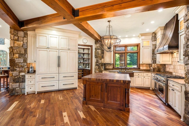 kitchen featuring custom exhaust hood, wooden counters, hanging light fixtures, a kitchen island, and range with two ovens