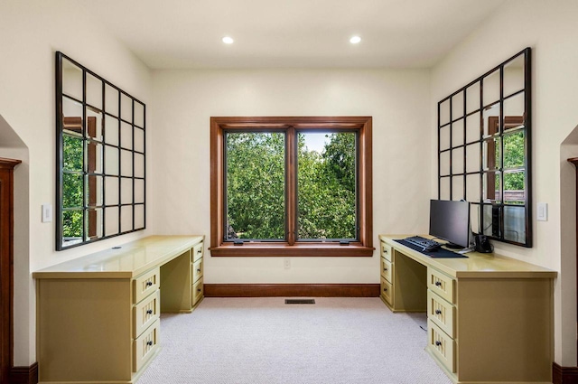 unfurnished office with light colored carpet and built in desk