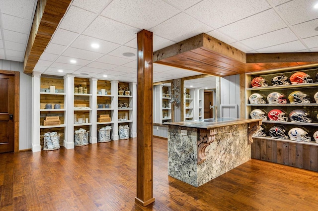 bar with wood-type flooring and built in shelves