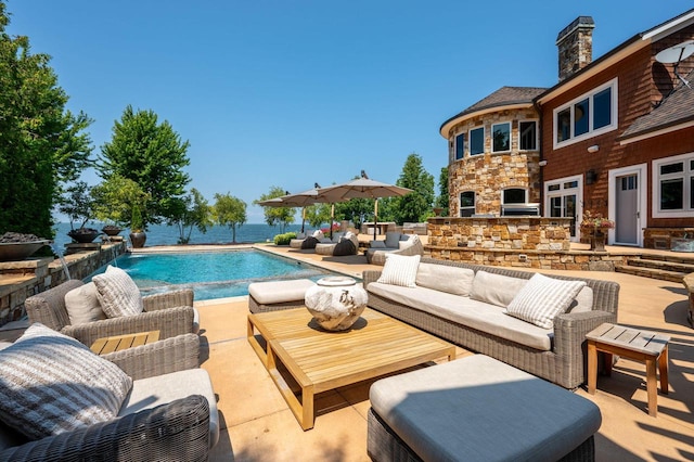 view of swimming pool with a patio area and an outdoor living space with a fireplace