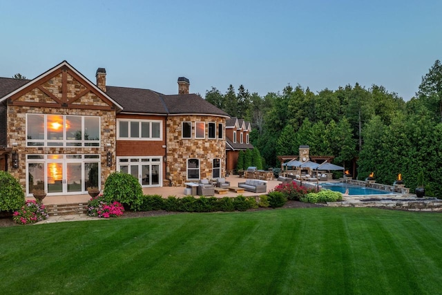 back of house with a balcony, an outdoor living space, a yard, and a patio area