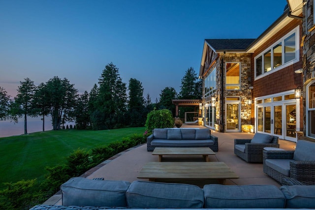 patio terrace at dusk featuring an outdoor hangout area, a pergola, a lawn, and french doors