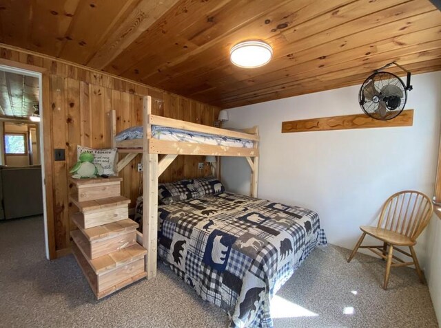 carpeted bedroom featuring wood ceiling and wooden walls