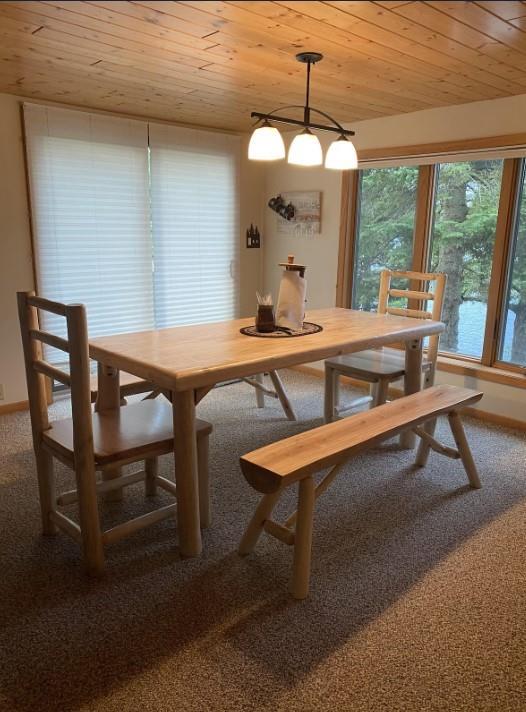 dining space featuring wood ceiling and carpet flooring